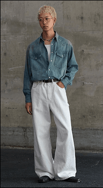 Model wearing blue denim seated on a stool