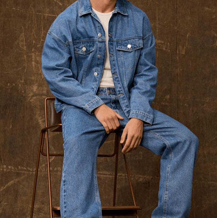 Model sitting in a denim set on a chair
